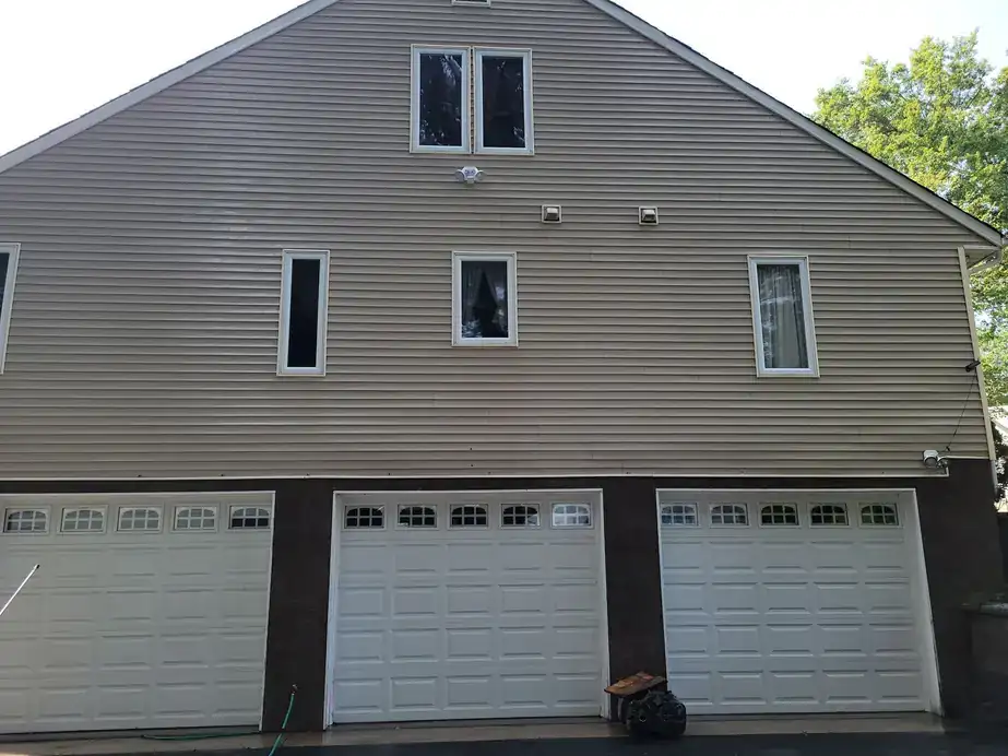 Three-car garage gable with grey vinyl siding after a Modern Powerwash house wash